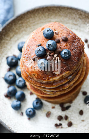 Buckwheat pancakes with cocoa nibs and blueberries. Closeup view, selective focus Stock Photo