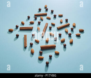 Chocolate balls, almonds, cinnamon in the shape of a diamond on a blue paper background. Flat lay Stock Photo