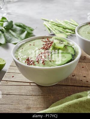 Vegetarian healthy smoothies with kiwi, cucumber and flax seeds in a plate on a wooden board Stock Photo