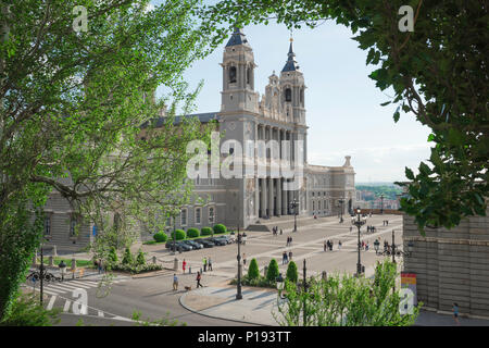Madrid cathedral, view through a canopy of trees in the Bailen Gardens towards the Catedral Nuestra Senora de la Almudena and Plaza Armeria in Madrid. Stock Photo