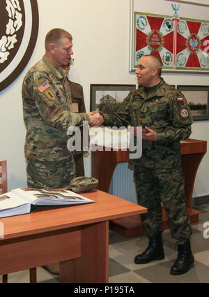 BIELSKO-BIAŁA, Poland – Lt. Col. Ryszard Burczy, commander of the Polish 18th Airborne Battalion, 6th Airborne Brigade, presents a plaque to Brig. Gen. Kenneth L. Kamper, deputy commanding general of 4th Infantry Division and leader of the Atlantic Resolve Mission Command Element, at the Polish 18th Airborne Battalion Headquarters in Bielsko-Biała, Poland, Oct. 5, 2016. During his visit, Kamper toured the facilities and met with leaders of the Polish 18th Airborne Battalion to discuss combined training in support of Operation Atlantic Resolve, a U.S. led effort in Eastern Europe that demonstra Stock Photo