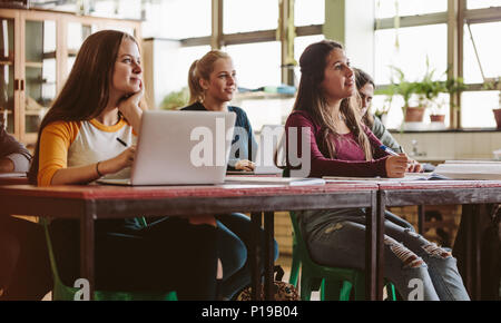 Attentive students listening to lecture in a classroom. Young people study at the university. Stock Photo