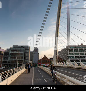 Dublin, Ireland - September 17, 2016: Cyclists use the 'segregated' cycle track on the modern cable-stayed Samuel Beckett Bridge in Dublin's redevelop