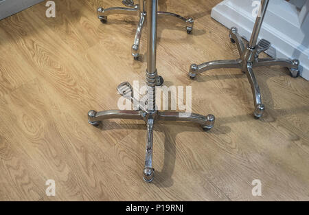 Wheeled traditional style dressmakers for mannequins over wooden floor. Closeup Stock Photo