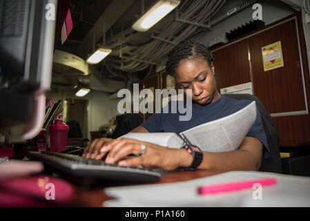161003-N-WC455-062    ARABIAN GULF (Oct. 3, 2016) Petty Officer 1st Class Chardae Longshore, from Augusta, Ga., reviews Uniform Code of Military Justice (UCMJ) articles to draft charges in the legal office of the aircraft carrier USS Dwight D. Eisenhower (CVN 69) (Ike). Longshore serves aboard Ike as a legalman, aiding Ike's crew in all matters in the field of law. Ike and its Carrier Strike Group are deployed in support of Operation Inherent Resolve, maritime security operations and theater security cooperation efforts in the U.S. 5th Fleet area of operations. (U.S. Navy photo by Seaman Joshu Stock Photo