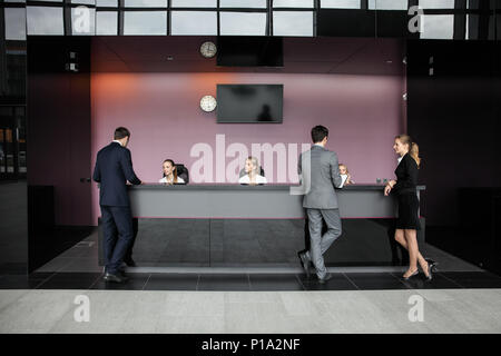 Business people at reception or front desk in office building, hotel or airport Stock Photo