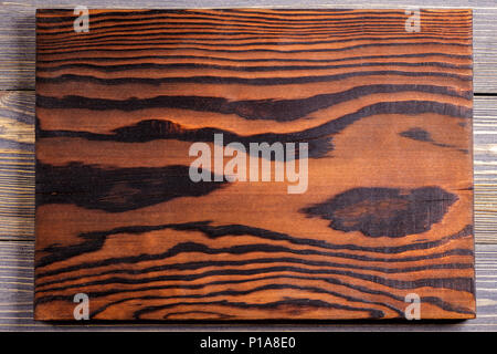 Cutting board from burnt wood. Wooden background. Stock Photo
