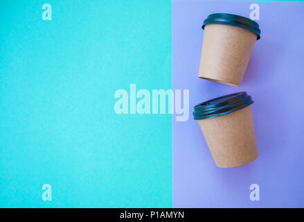 Two paper cups for hot drinks on blue and violet background with text space. Stock Photo