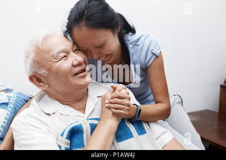 Affectionate, smiling senior father and daughter hugging