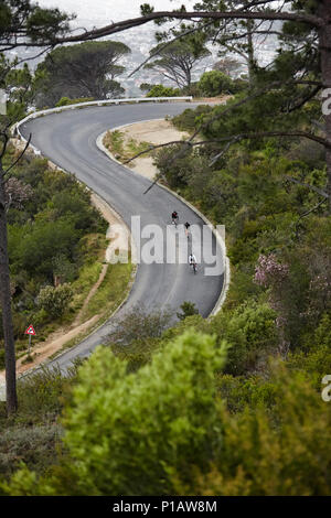 Cyclists cycling downhill on road Stock Photo