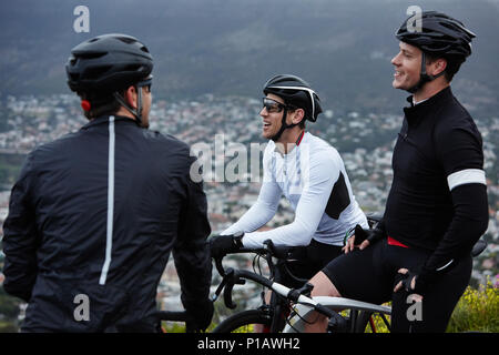 Male cyclist friends taking a break, talking Stock Photo