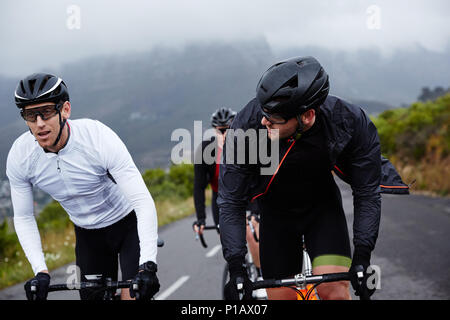 Male cyclist friends cycling on road Stock Photo