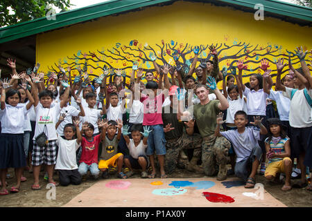 U.S. Marines with Bravo Company, 9th Engineer Support Battalion, 3d Marine Logistics Group, III Marine Expeditionary Force, pose for a photo with the students of the Palawig Elementary School prior to placing hand prints on a wall that was restored during Philippine Amphibious Landing Exercise 33 (PHIBLEX) in Cagayan Valley, Philippines, Oct. 10, 2016. PHIBLEX is an annual U.S.-Philippine military bilateral exercise that combines amphibious capabilities and live-fire training with humanitarian civic assistance efforts to strengthen interoperability and working relationships. (U.S. Marine Corps Stock Photo