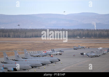 A variety of units aircraft and personnel, including U.S. Marine Corps F/A-18C Hornet aircraft and personnel from Marine Fighter Attack Squadron 232 out of Marine Corps Air Station Miramar, Calif., gather in their ramp space as a pair of U.S. Air Force F-16 Fighting Falcon aircraft assigned to the 36th Fighter Squadron out of Osan Air Base, Republic of Korea, prepare to land at Eielson Air Force Base, Alaska, Oct. 10, 2016, after the first RED FLAG-Alaska (RF-A) 17-1 combat training mission. Pacific Air Forces commander-directed field training exercises like RF-A are vital to maintaining peace Stock Photo