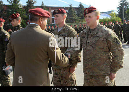 BIELSKO-BIAŁA, Poland – Lt. Col. Ryszard Burczy, commander of the Polish 18th Airborne Battalion, 6th Airborne Brigade, presents a coin to Spc. Robert Covey, TOW gunner, assigned to Company D, 2nd Battalion, 503rd Infantry Regiment, 173rd Airborne Brigade, during a ceremony hosted at the 18th Airborne Battalion Headquarters in Bielsko-Biała, Poland, Oct. 14, 2016. The ceremony was part of an annual celebration and public open house event honoring the history of the 18th Airborne Battalion. The “Sky Soldiers” of D Co., 2nd Bn., 503rd Inf. Regt. are in Poland on a training rotation in support of Stock Photo