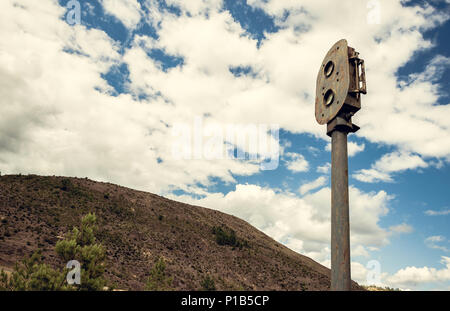 Old rusty train semaphore with sky and mountain background in the old station of Zaranda, Spain Stock Photo