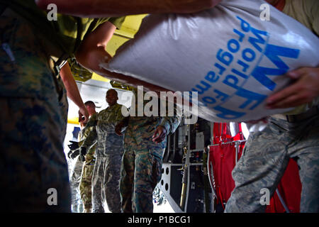 U.S. service members unload rice from a World Food Programme truck onto a CH-47, Oct. 11, 2016 in Port-Au-Prince, Haiti. The Airmen are working alongside Haitian citizens to provide relief after the nation was struck by Hurricane Matthew. JTF Matthew was a U.S. Southern Command lead humanitarian assistance, disaster relief effort in Haiti following Hurricane Matthew. Matthew was a category 4 hurricane that formed in the Western Atlantic Ocean and affected Haiti, eastern Cuba, and the Bahamas before moving up the southeast coast of the United States. (U.S. Air Force Photo by Tech. Sgt. Russ Sca Stock Photo