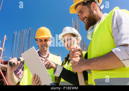 Architect or manager showing to her colleagues electronic building plan Stock Photo