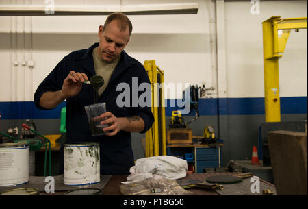 Staff Sgt. Kyle Morris, 435th Construction and Training Squadron aircraft arresting systems depot technician, mixes paint at Ramstein Air Base, Germany, Oct. 13, 2016. Morris mixed the paint to spray over dents and chips on a BAK-12 aircraft arresting system during an overhaul. The 435th CTS is the only squadron within U.S. Air Forces in Europe with the capability to overhaul the systems. (U.S. Air Force photo by Senior Airman Tryphena Mayhugh) Stock Photo