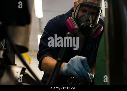 Staff Sgt. Kyle Morris, 435th Construction and Training Squadron aircraft arresting systems depot technician, sprays paint on a BAK-12 aircraft arresting system at Ramstein Air Base, Germany, Oct. 12, 2016. The systems decelerate aircraft during landing and require an overhaul every ten years. The 435th CTS overhauls all aircraft arresting systems within U.S Air Forces in Europe. (U.S. Air Force photo by Senior Airman Tryphena Mayhugh) Stock Photo