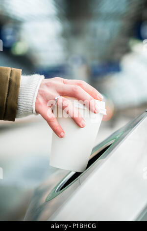 Woman using waste separation container throwing away coffee cup Stock Photo