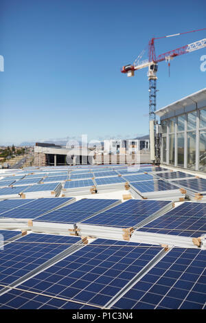 Solar panels stacked on sunny rooftop Stock Photo