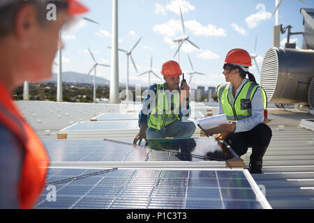 Engineers examining solar panels at alternative energy power plant Stock Photo