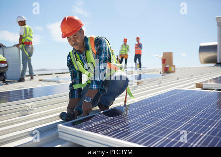 Engineer installing solar panels at sunny power plant Stock Photo