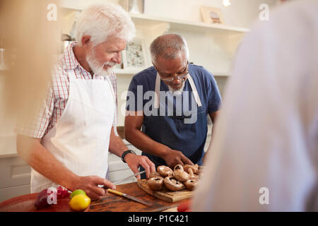 Senior men friends cutting mushrooms in cooking class Stock Photo