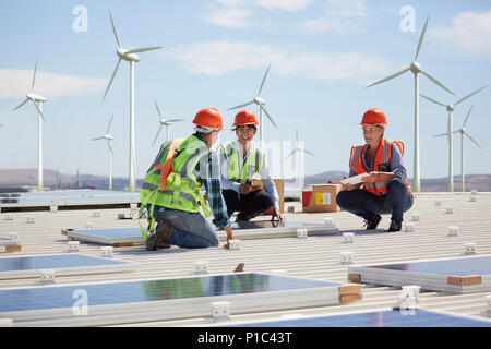 Engineers installing solar panels at alternative energy power plant Stock Photo