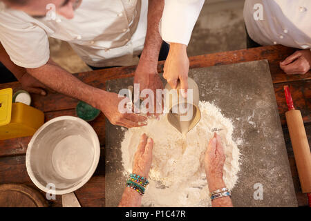 Overhead view chefs making pizza dough flour nest Stock Photo