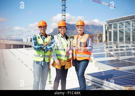 Portrait confident, smiling engineers at sunny solar power plant Stock Photo