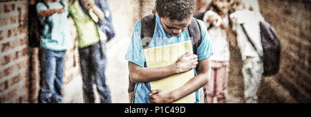 Sad pupil being bullied by classmates at corridor Stock Photo