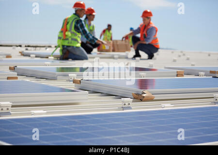 Engineers installing solar panels at sunny power plant Stock Photo