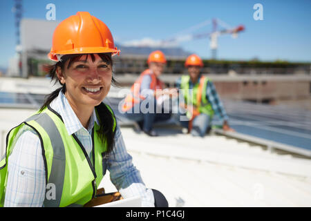 Portrait smiling, confident female engineer at sunny power plant Stock Photo