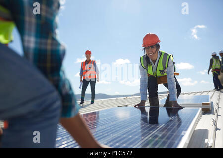 Engineers lifting solar panel at sunny power plant Stock Photo