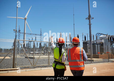 Workers watching wind turbine at power plant Stock Photo