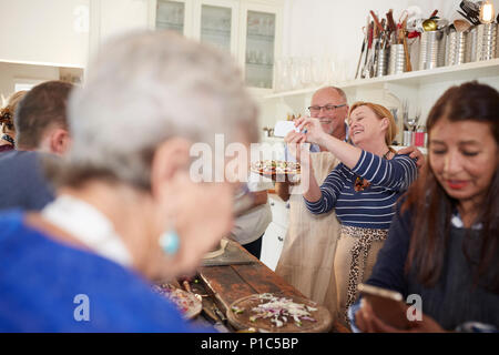 Senior couple taking selfie with pizza in cooking class Stock Photo