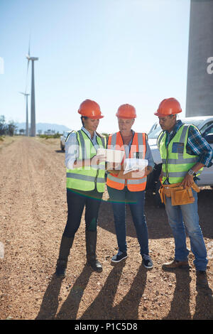 Engineer and workers using digital tablet at wind turbine power plant Stock Photo