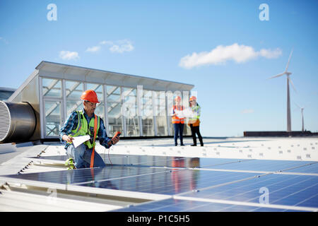 Engineer testing solar panels at sunny power plant Stock Photo