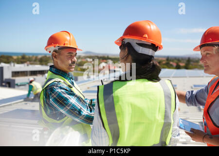 Workers talking at solar power plant Stock Photo