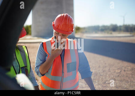 Female worker using walkie-talkie at power plant Stock Photo