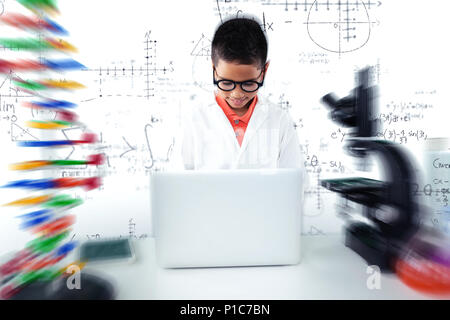 Composite image of schoolboy using laptop at desk Stock Photo