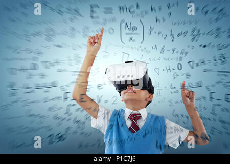 Composite image of schoolboy wearing virtual reality headset enjoying Stock Photo