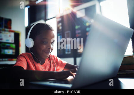 Boy listening music while using laptop Stock Photo