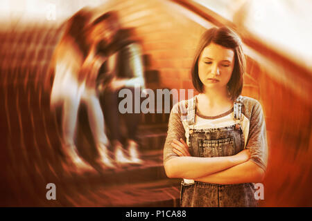 School friends bullying a sad girl in school corridor Stock Photo
