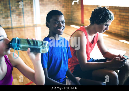 High school kids relaxing on bench Stock Photo