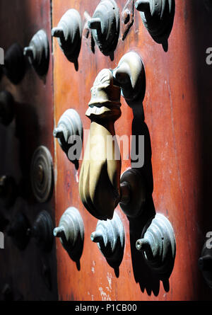 A traditional hand door-knocker on a studded oak door in Andalucía, Spain. Stock Photo