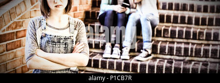 School friends bullying a sad girl in school corridor Stock Photo