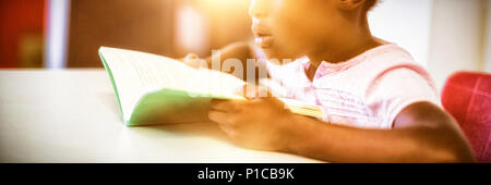 Girl reading a book in the classroom Stock Photo